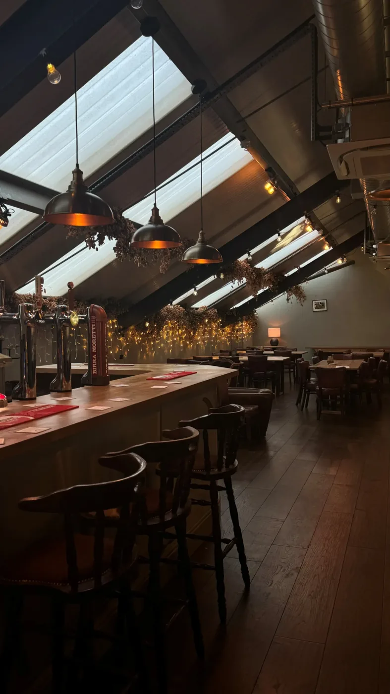 The private dining room upstairs at The Longhorn, with its own bar and tables under warm pendant lights
